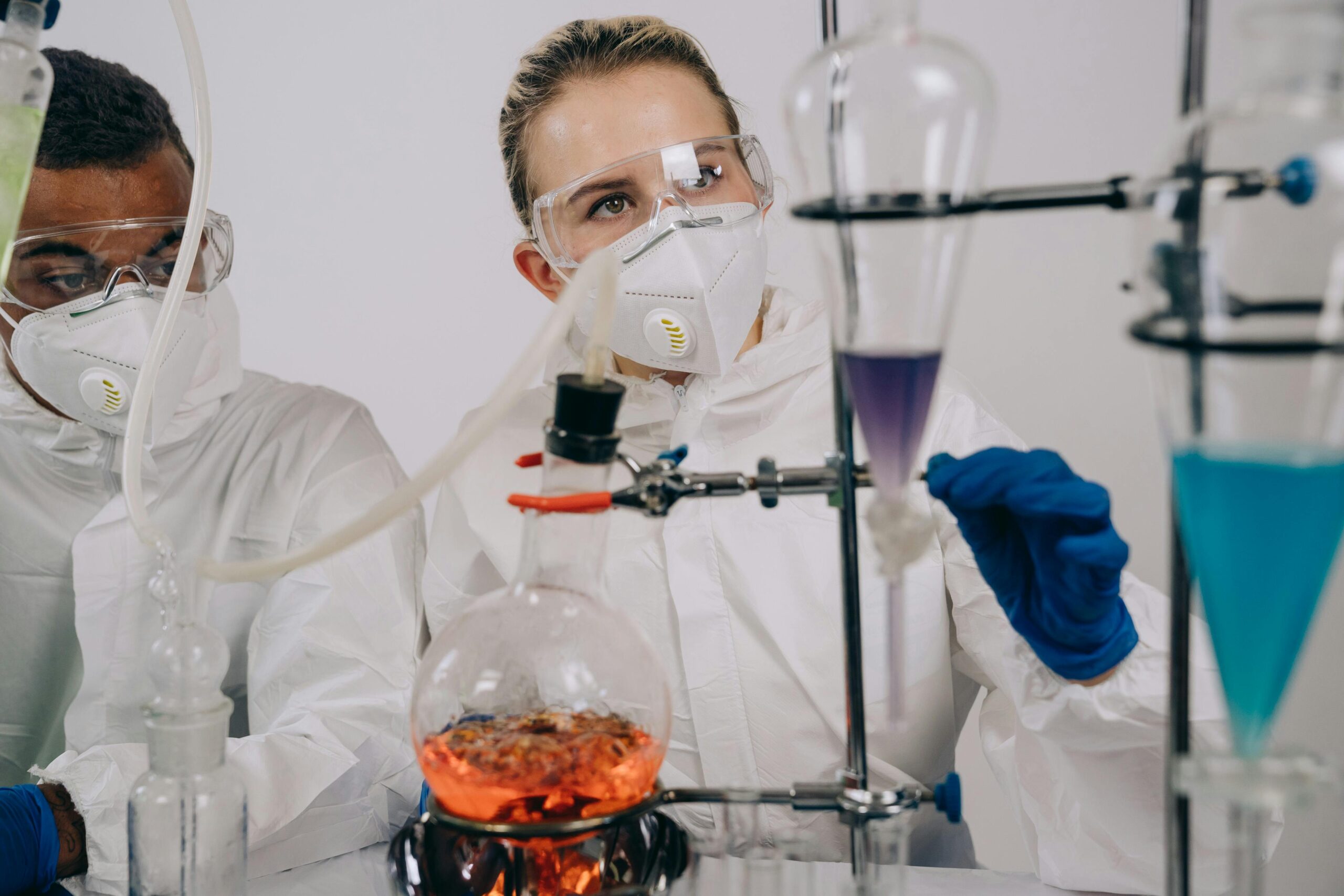Team of chemists in protective gear conducting a complex laboratory experiment.